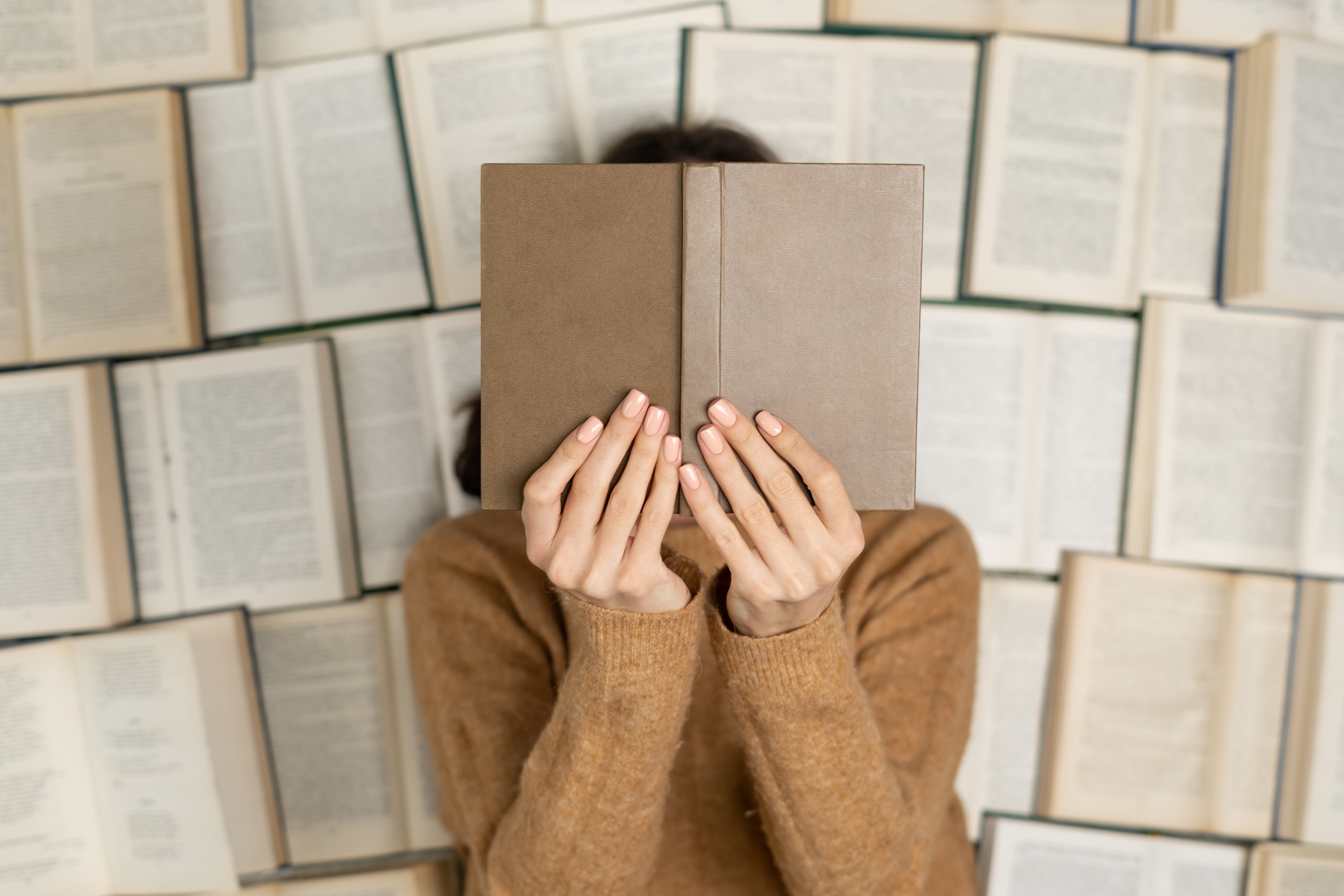 top-view-woman-cozy-soft-sweater-lies-open-books